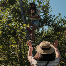 Jenna spotting Aleezah as she climbs a ladder 
