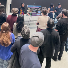 Aleezah, Elissa, and Oli speaking with a group of guests